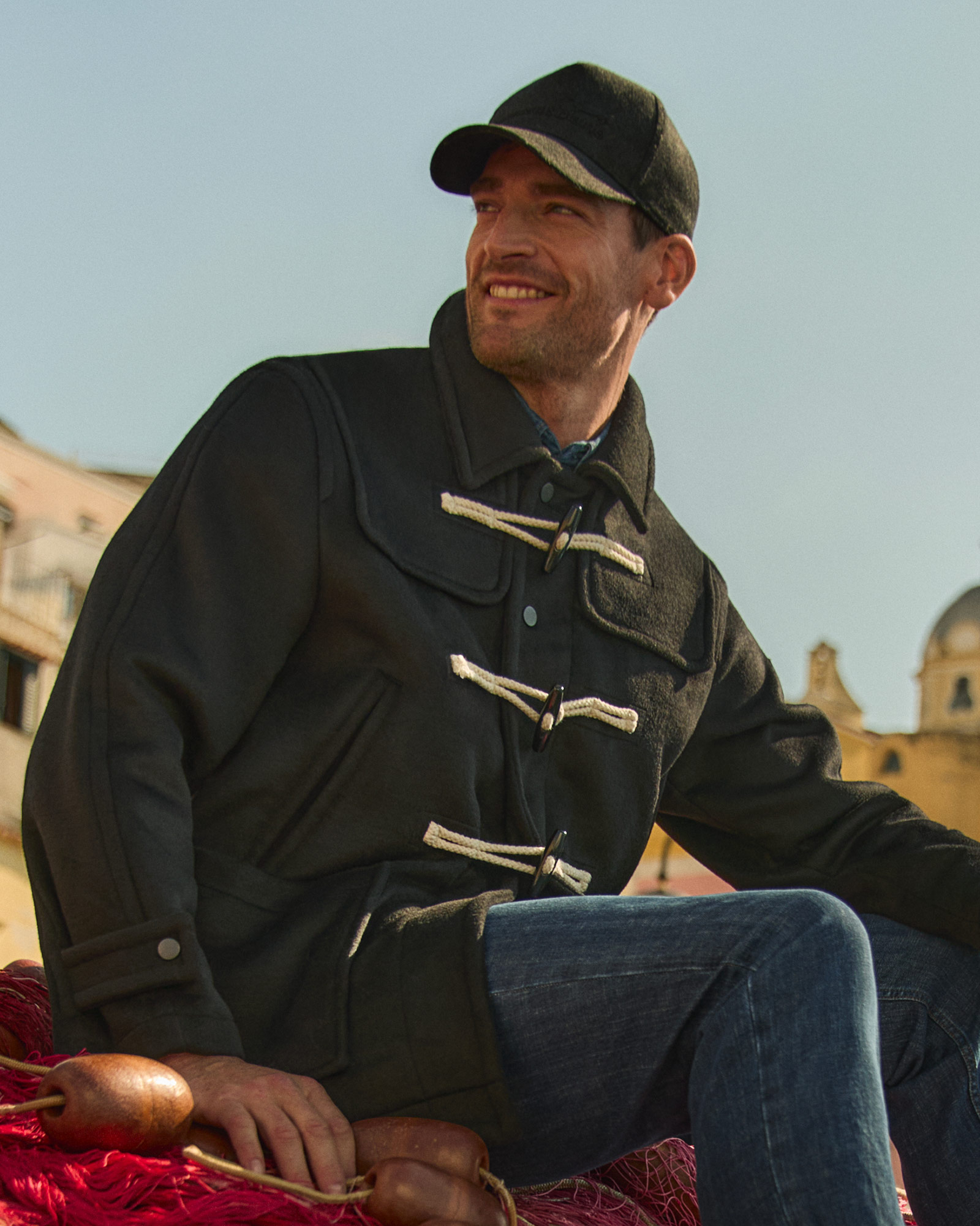 Uomo con polo blu navy a maniche lunghe e pantaloni beige